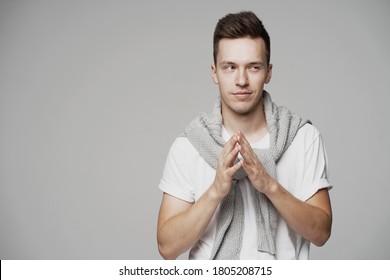 A Young Man Of European Appearance Thinks, Makes A Gesture With His Hands And Does Not Understand. Look Away. Grey Jacket Is Warm. Sly Closed His Eyes