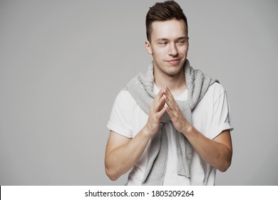 A Young Man Of European Appearance Thinks, Makes A Gesture With His Hands And Does Not Understand. Look Away. Grey Jacket Is Warm. Sly Closed His Eyes