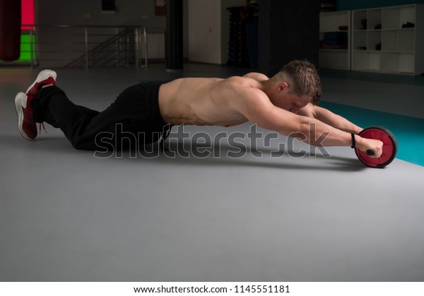 Young Man Exercising Fitness Workout For Abdominal\
With Toning Wheel