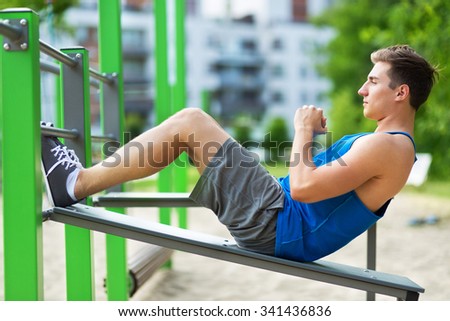 Young man exercising at outdoor gym
