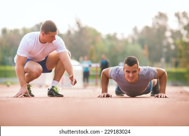 Young Man Exercising With Personal Trainer