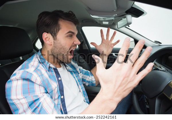 Young man\
experiencing road rage in his\
car
