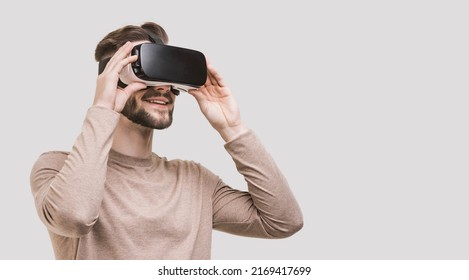 Young man experiencing virtual reality headset, Isolated on grey background. VR, future, gadgets, meta verse, technology, education online, studying, video game concept
