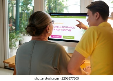 Young Man Explaining Grandmother How To Order Insurance Policy Online