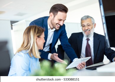 Young Man Explaining His Business Plans To His Colleagues.
