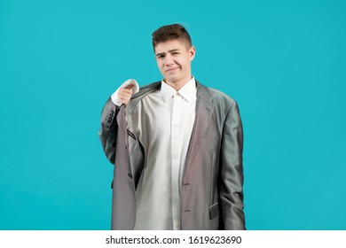 The Young Man Expresses Dissatisfaction With The Fact That He Was Dressed In A Shirt And A Jacket Of An Adult. The Clothes Are Too Big For A Boy