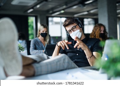 Young Man With Face Mask Back At Work Or School In Office After Lockdown, Having Fun.