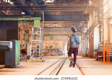 Young man in a factory in protective workwear