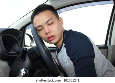 A Young Man Falling Asleep At The Steering Wheel