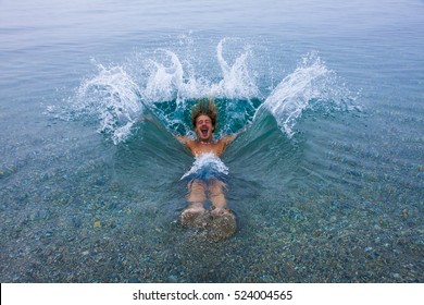 Young Man Falling Backwards Into The Ocean