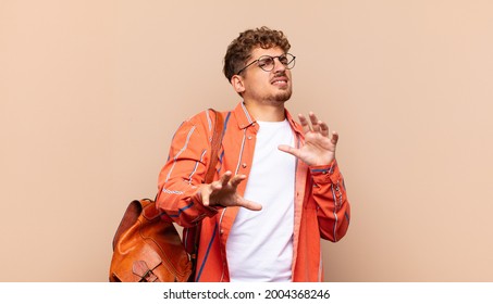 Young Man Feeling Disgusted And Nauseous, Backing Away From Something Nasty, Smelly Or Stinky, Saying Yuck. Student Concept