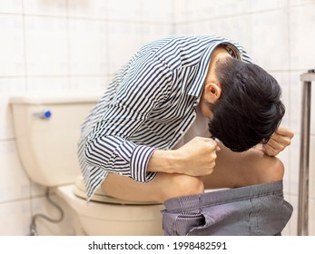 Young man feels uncomfortable in his stomach and is constipated in the toilet