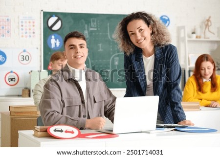 Young man with female instructor having lesson at driving school