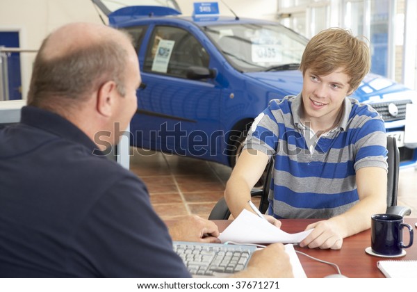Young man
filling in paperwork in car
showroom