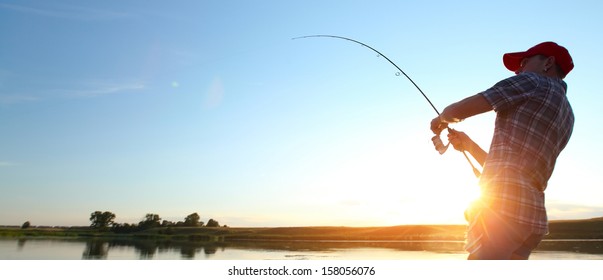 Young Man Fishing At Sunset