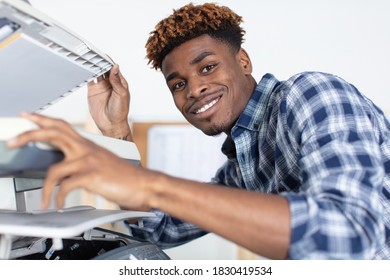 Young Man Fixing Photo Copier