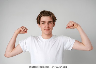 Young Man Flexing Muscles in Front of White Background - Powered by Shutterstock