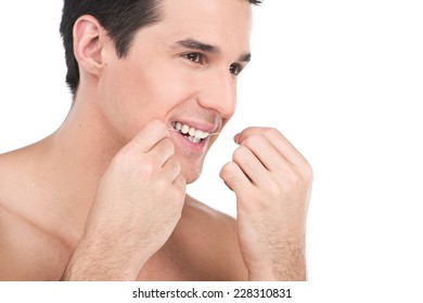 Young Man Flossing His Teeth Isolated On White Background. Guy Is Flossing His Teeth In Front Of Bathroom Mirror