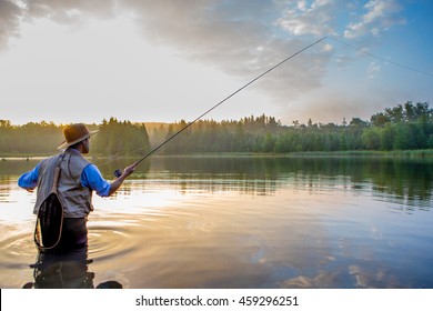 Young man flyfishing at sunrise - Shutterstock ID 459296251