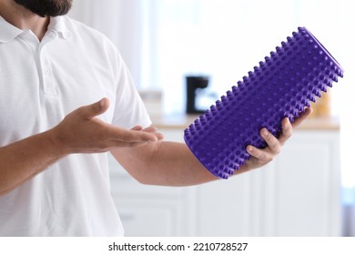 Young Man With Foam Roller In Kitchen, Closeup