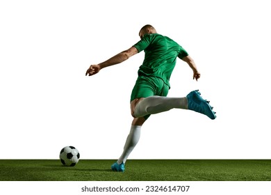 Young man, football player in green uniform in motion, kicking ball, training, playing against white background. Concept of professional sport, action, lifestyle, competition, hobby, training, ad - Powered by Shutterstock