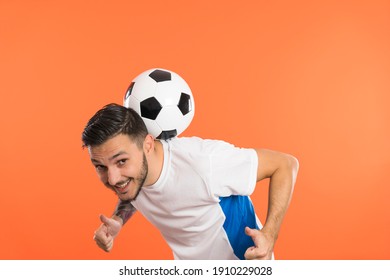 Young Man football soccer player balancing soccer ball on the back of neck and giving thumbs up - Shutterstock ID 1910229028