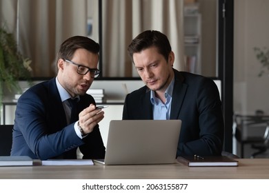 Young Man In Formal Suit Insurance Broker Lawyer Consult Client On Workplace Before Pc Screen Offer Service Discuss Electronic Agreement Text. Skilled Employee Mentor Explain Newbie Intern Work Online