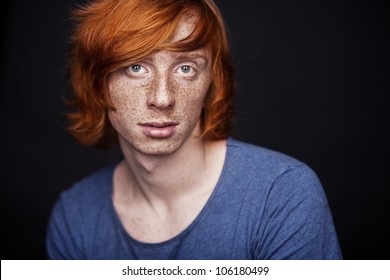 Young Man With Freckles On Black Background