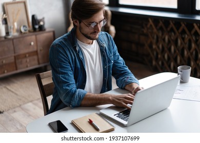 Junge Freiberufler mit Laptop-Lernen online arbeiten von zu Hause aus, glücklicher flüchtiger Kerl tippen auf Notebook