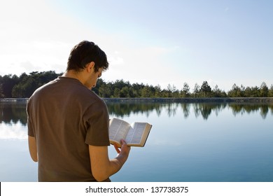 Young Man In Front Of Lake Reading The Bible (King James Version)