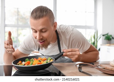 Young Man Frying Vegetables In Kitchen, Closeup