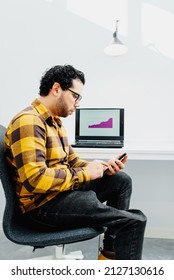 Young Man With Functional Diversity Using His Smartphone And Checking Statistics At Work In The Office. Inclusion And Diversity In The Work Environment