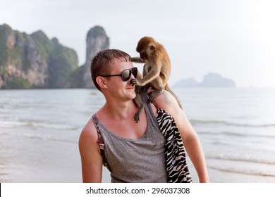 Young Man With Funny Monkey Sitting On His Shoulder, Touching His Nose, Tropical Country