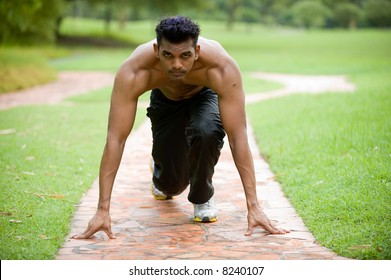 A Young Man Getting Ready To Run Outside In Track Pants