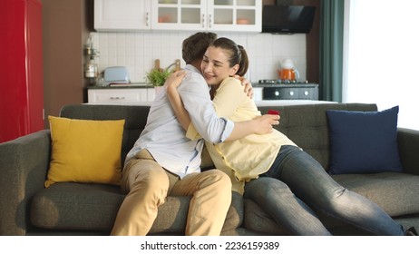 A young man gives his girlfriend a nice gift for Valentine's Day. Young couple happily hugging each other. Marriage proposal. - Powered by Shutterstock