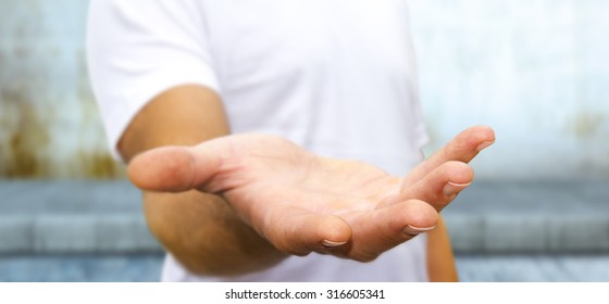 Young man giving empty hand on office background