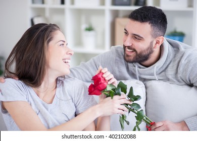 Young Man Giving A Red Rose To His Girlfriend