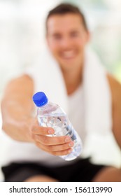 Young Man Giving Water Bottle In Gym