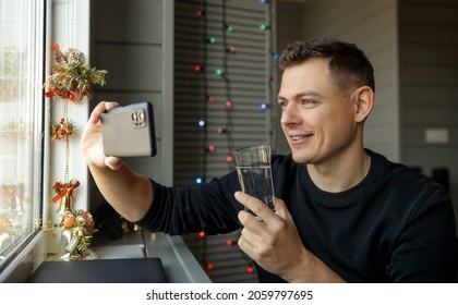 Young Man With Glass Making Facetime Video Calling To Congratulate Merry Christmas His Relatives.