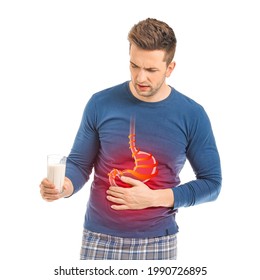 Young Man With Glass Of Milk Suffering From Heartburn On White Background