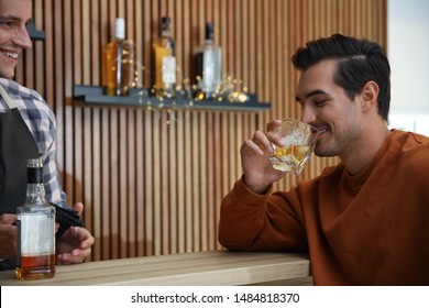 Young Man With Glass Of Whiskey In Bar