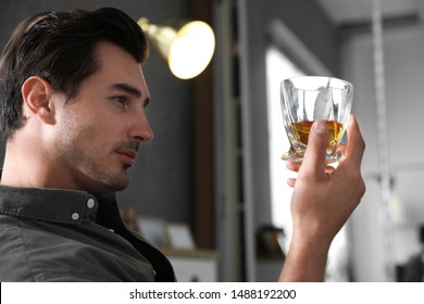 Young Man With Glass Of Whiskey At Home