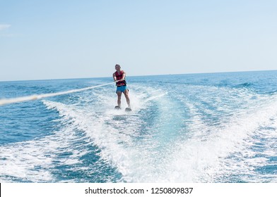 Young Man Glides On Water Skiing On The Waves On The Sea, Ocean. Healthy Lifestyle. Positive Human Emotions, Joy. Family Are Spending Time At Tropical Ocean In The Day Time. New Zealand.