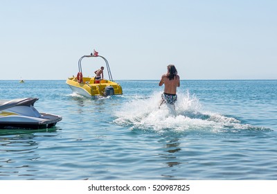 Young Man Glides On Water Skiing On The Waves On The Sea, Ocean. Healthy Lifestyle. Positive Human Emotions, Feelings, Joy. Funny Cute Boy Making Vacations And Enjoying Summer.