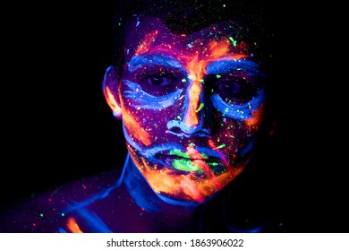Young man with glow paint on face. 