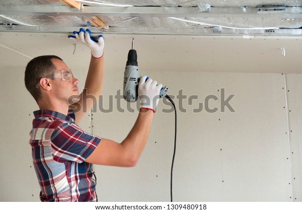 Young Man Goggles Fixing Drywall Suspended People Stock Image