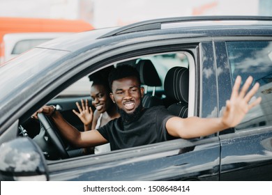 Young Man Greeting Someone While Drive Car On The Street