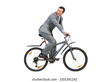 Young Man In Grey Business Suit On Bike. Happy Businessman Riding Bicycle. Handsome Male Cyclist Looking Back Isolated On White Background. Eco Friendly Personal Vehicle To Work Concept.