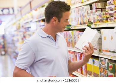 Young Man Grocery Shopping In Supermarket