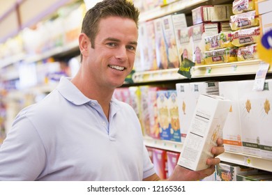 Young Man Grocery Shopping In Supermarket